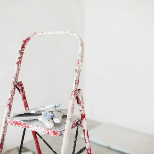 Close up ladder with putty knives over white background isolated